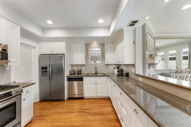 a large kitchen with a sink and stainless steel appliances