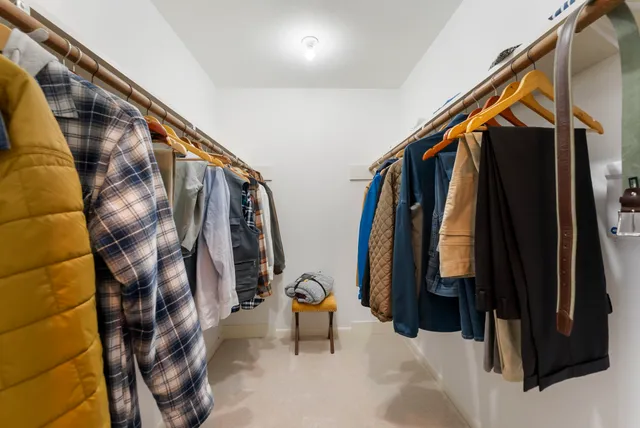 a view of walk in closet with clothes and shoes
