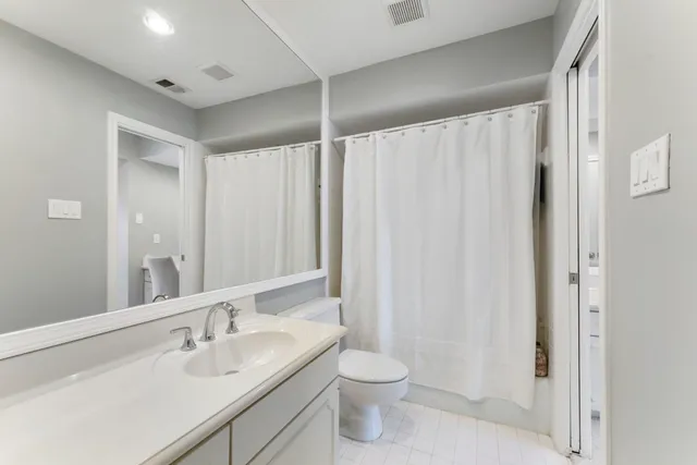 a bathroom with a granite countertop sink a toilet and shower