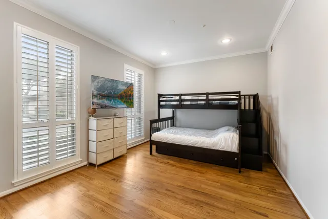 a bedroom with wooden floor and window
