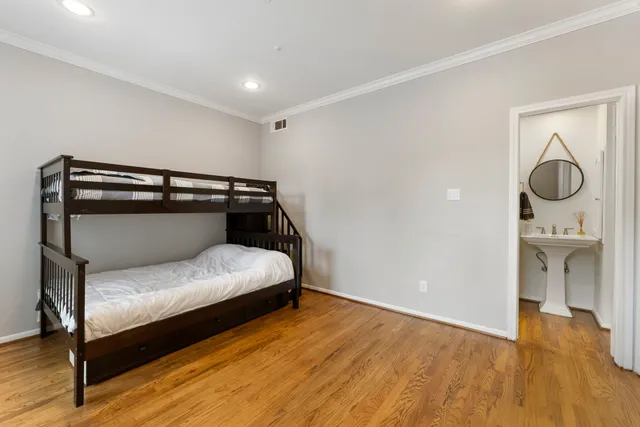 a bedroom with a bed and wooden floor