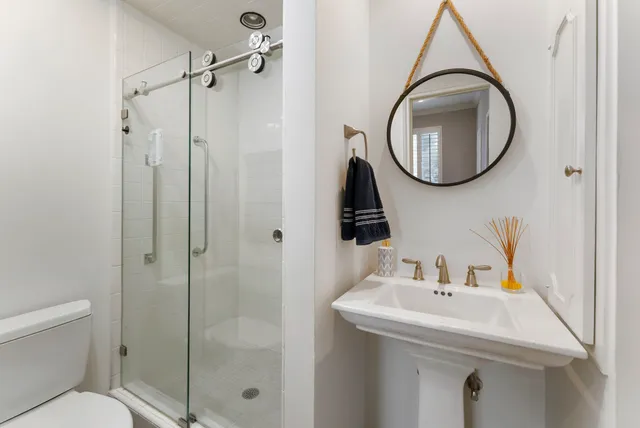 a bathroom with a sink a mirror a toilet and a mirror