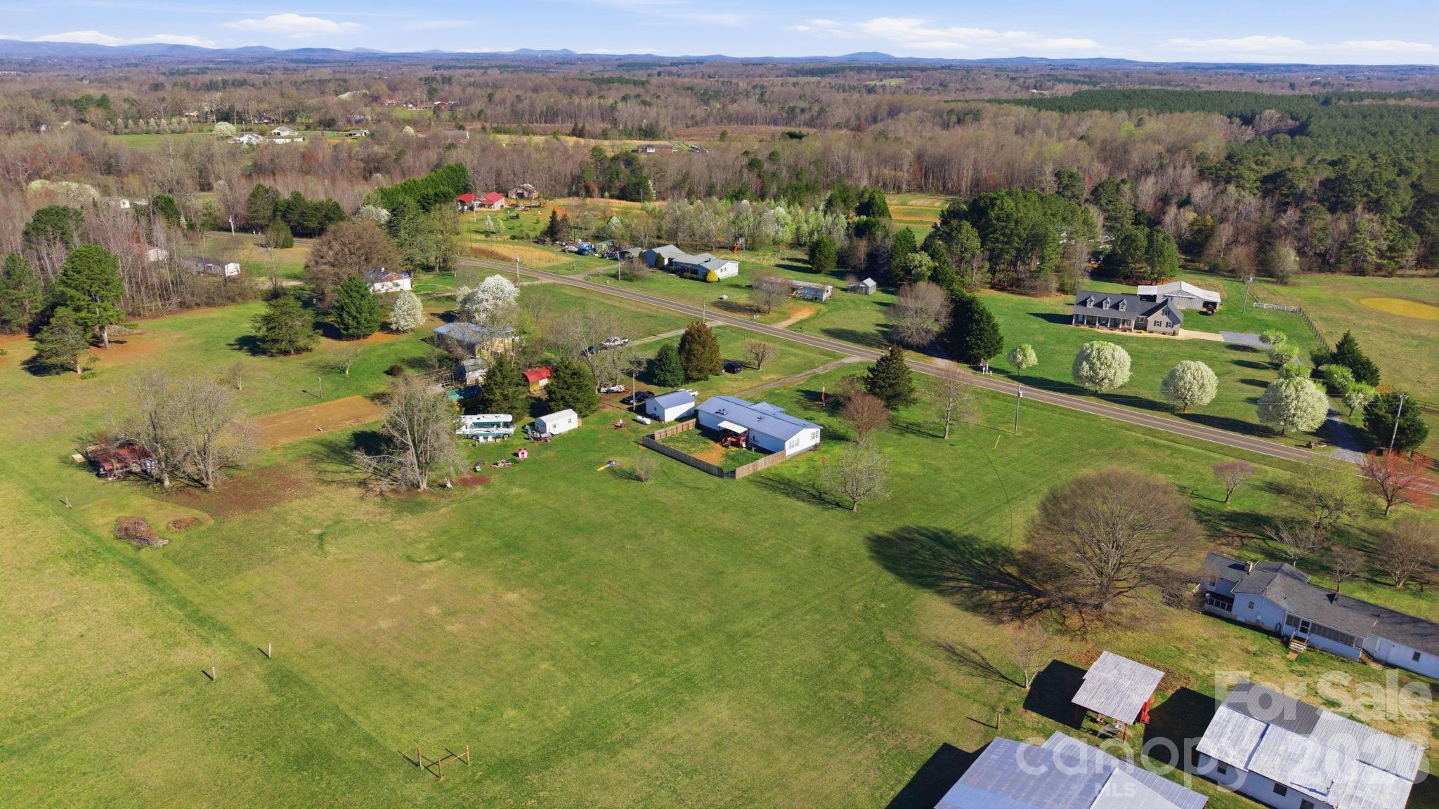 139 Old Fallston Road Cherryville, NC 28021 - Photo 7 of 47 an aerial view of green landscape with trees houses and mountain view