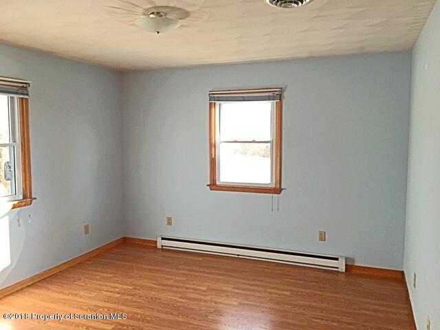1668 Pennay Hill Road Kingsley, PA 18826 - Photo 12 of 23 a view of an empty room with wooden floor and a window