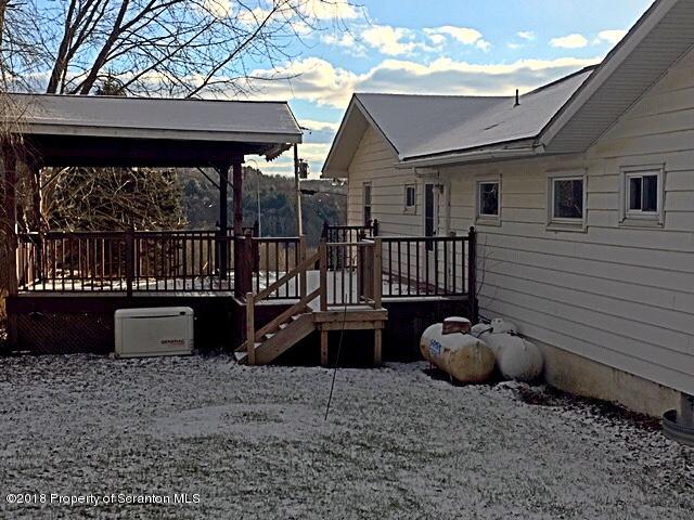 1668 Pennay Hill Road Kingsley, PA 18826 - Photo 5 of 23 a view of a deck with a couches chairs and wooden fence