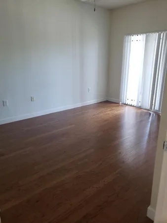 a view of an empty room with wooden floor