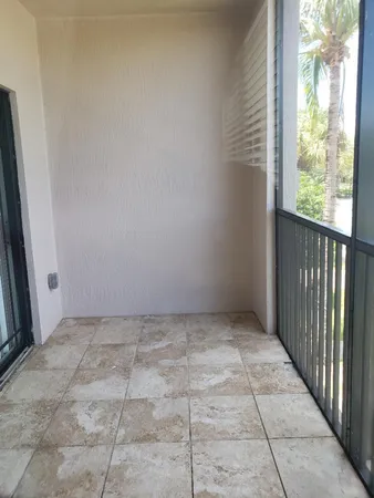 an empty room with wooden floor and windows with curtains