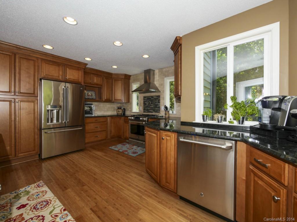 8108 Rising Meadow Road Charlotte, NC 28277 - Photo 11 of 21 a kitchen with stainless steel appliances granite countertop a refrigerator a sink dishwasher a stove and white countertops with wooden floor