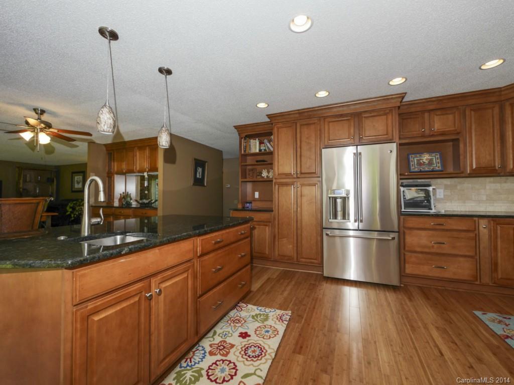 8108 Rising Meadow Road Charlotte, NC 28277 - Photo 10 of 21 a kitchen with stainless steel appliances granite countertop a refrigerator a sink dishwasher a oven and a dining table with wooden floor