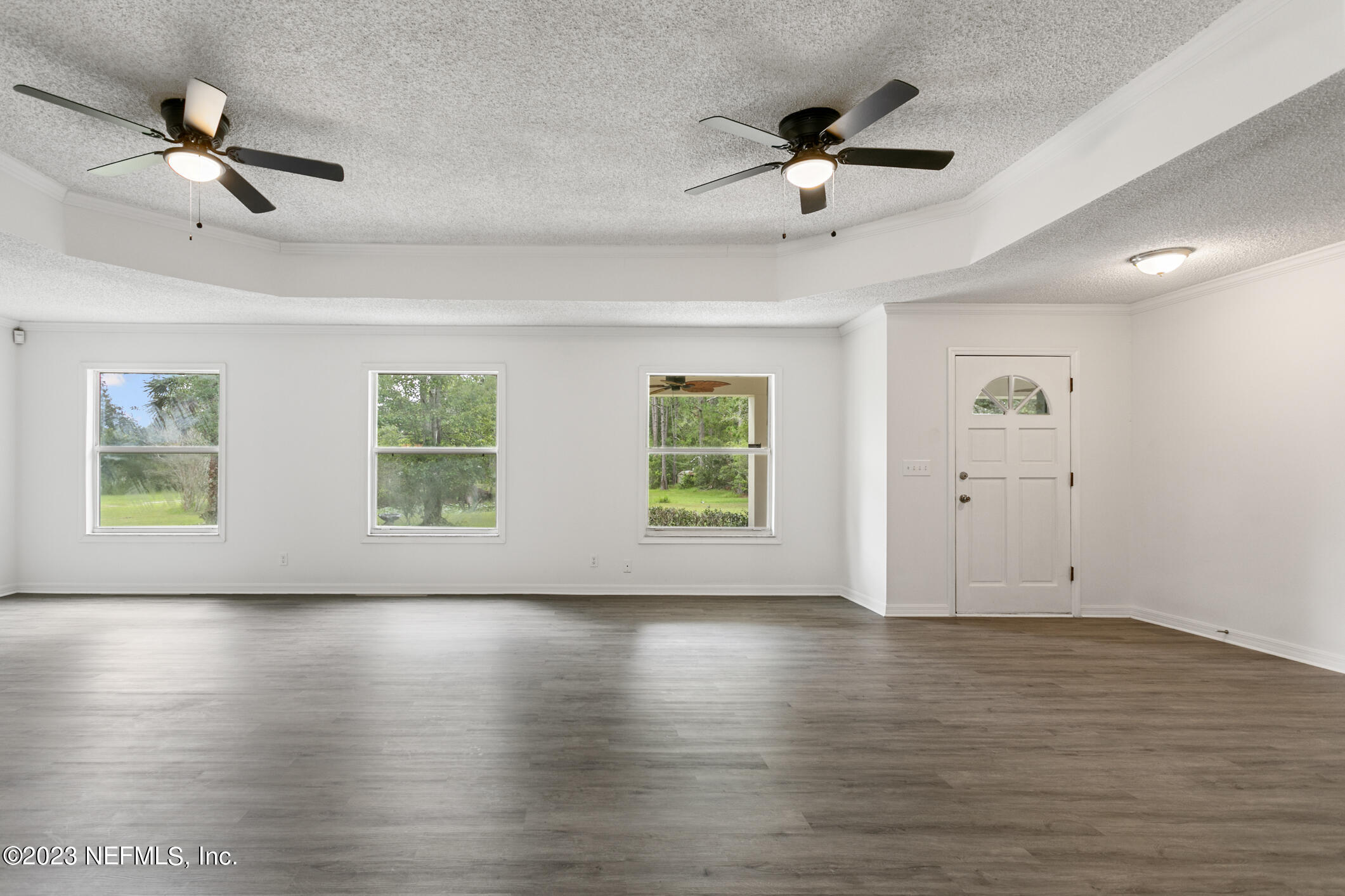 2555 Pacetti Road, Unit AC St. Augustine, FL 32092 - Photo 11 of 50 a view of an empty room with wooden floor and ceiling fan