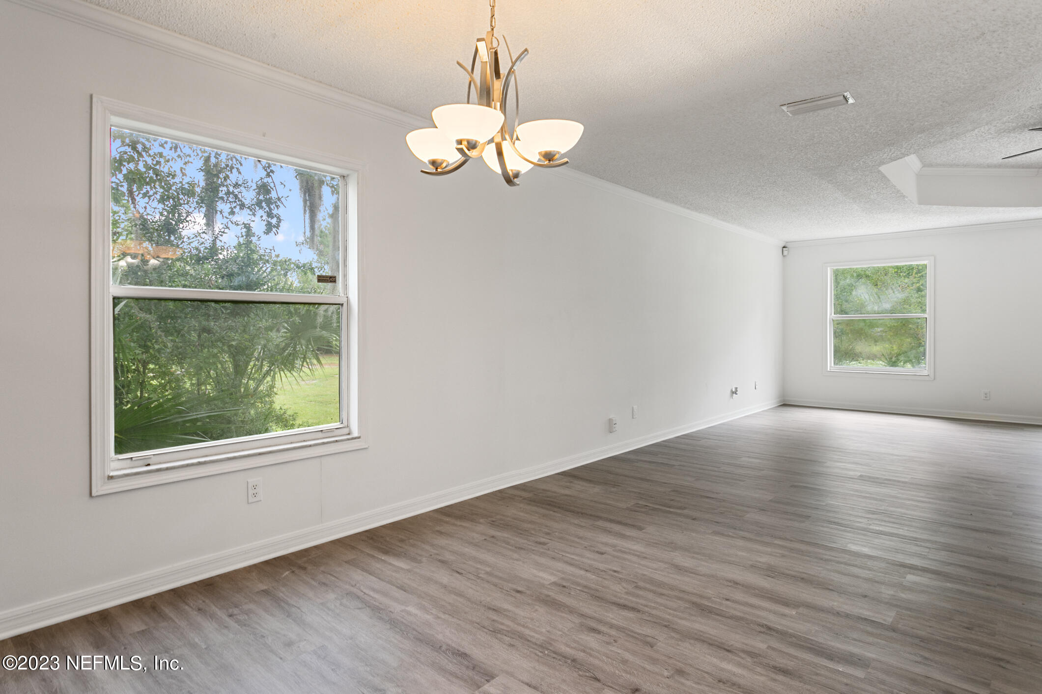 2555 Pacetti Road, Unit AC St. Augustine, FL 32092 - Photo 14 of 50 a view of an empty room with wooden floor and a window