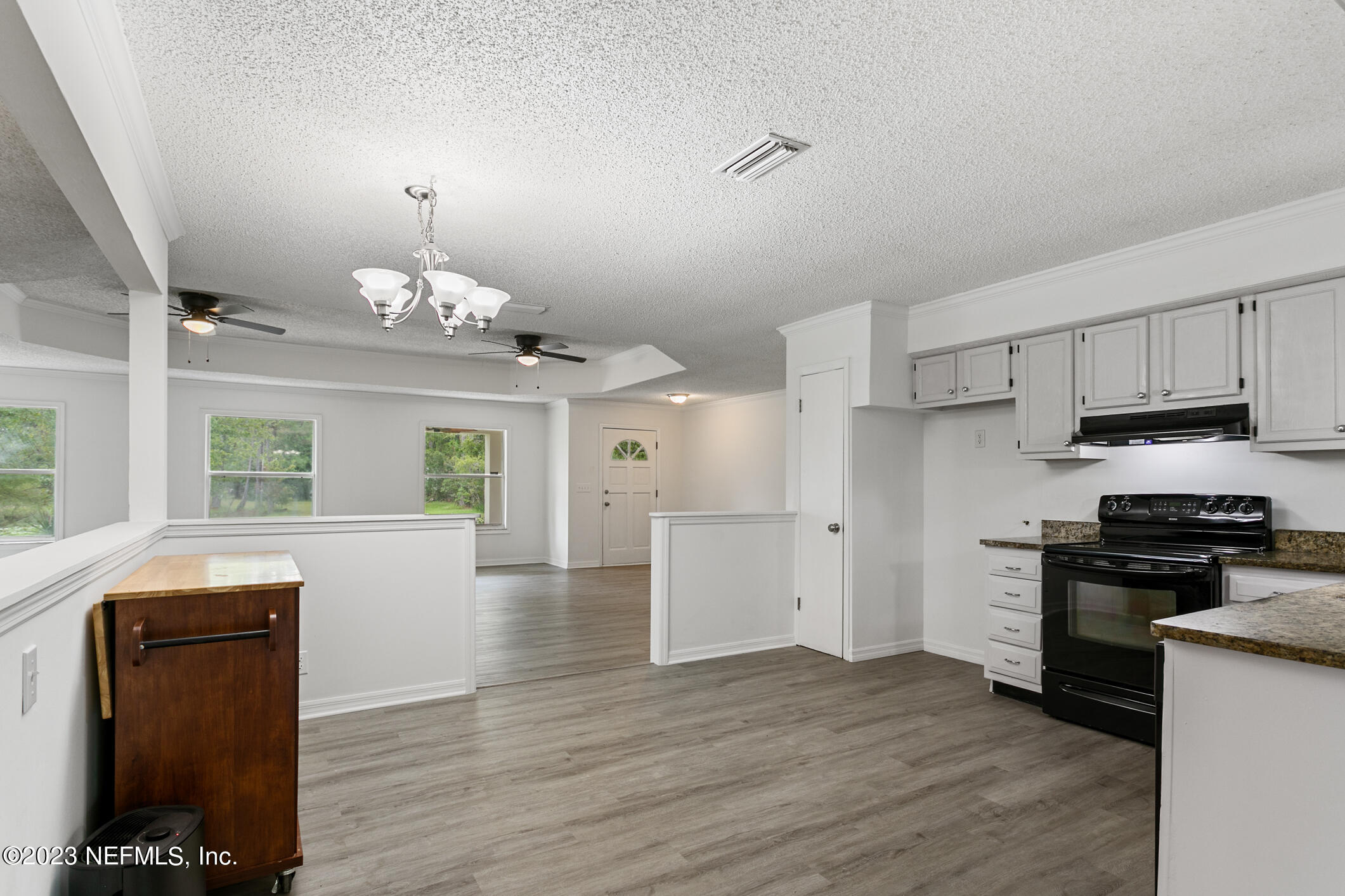 2555 Pacetti Road, Unit AC St. Augustine, FL 32092 - Photo 17 of 50 a view of a kitchen with a stove wooden cabinets and wooden floor