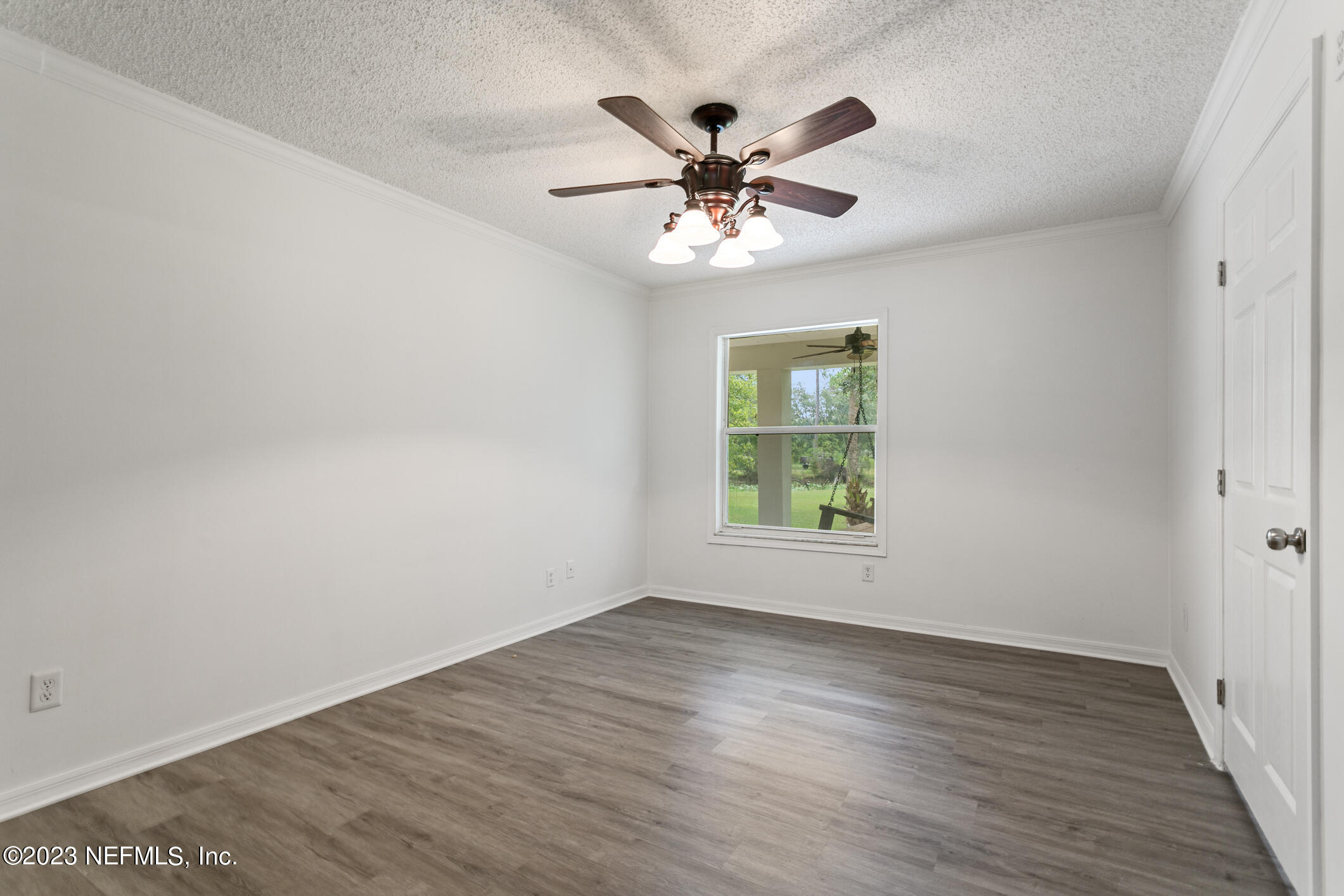 2555 Pacetti Road, Unit AC St. Augustine, FL 32092 - Photo 27 of 50 an empty room with wooden floor chandelier fan and windows