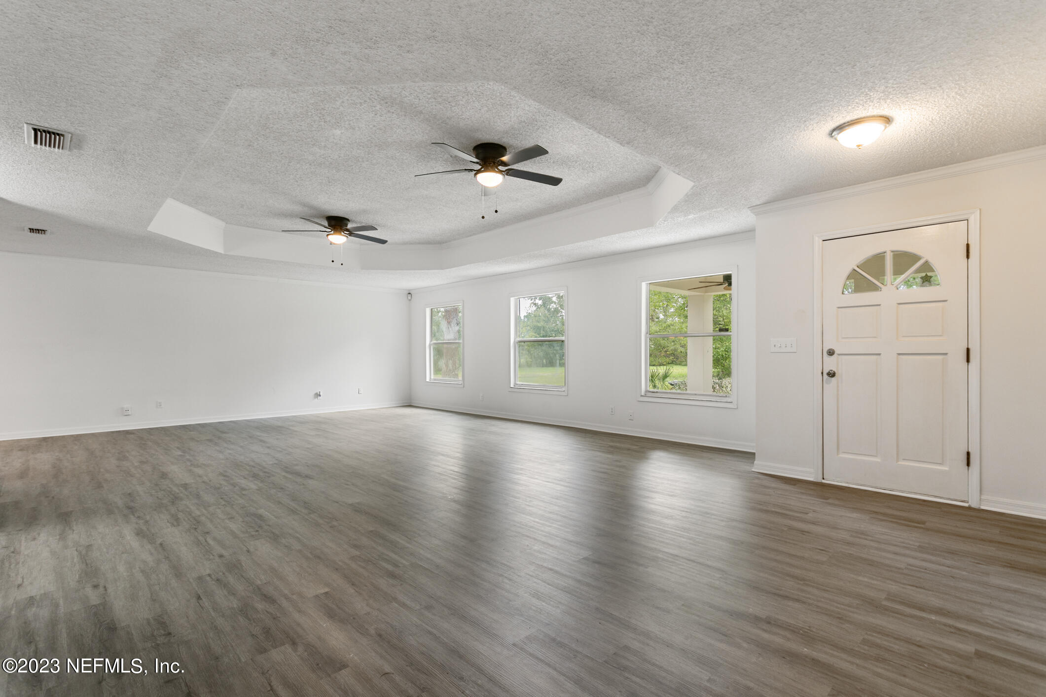 2555 Pacetti Road, Unit AC St. Augustine, FL 32092 - Photo 8 of 50 an empty room with wooden floor chandelier fan and windows