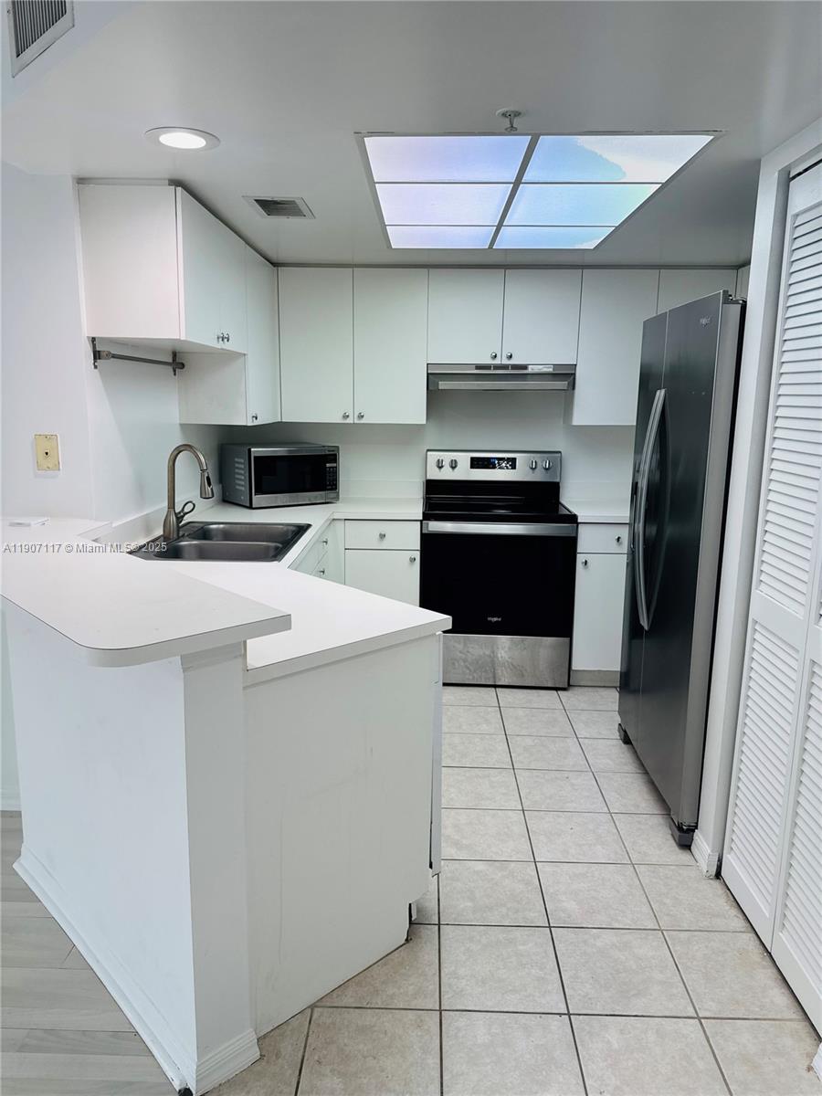 2009 Southeast 10th Avenue, Unit 315 Fort Lauderdale, FL 33316 - Photo 3 of 9 a kitchen with stainless steel appliances a sink a stove a refrigerator and cabinets