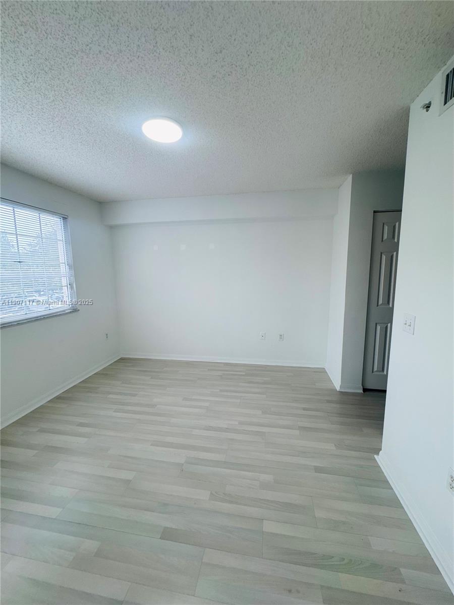 2009 Southeast 10th Avenue, Unit 315 Fort Lauderdale, FL 33316 - Photo 5 of 9 a view of an empty room with wooden floor and a window