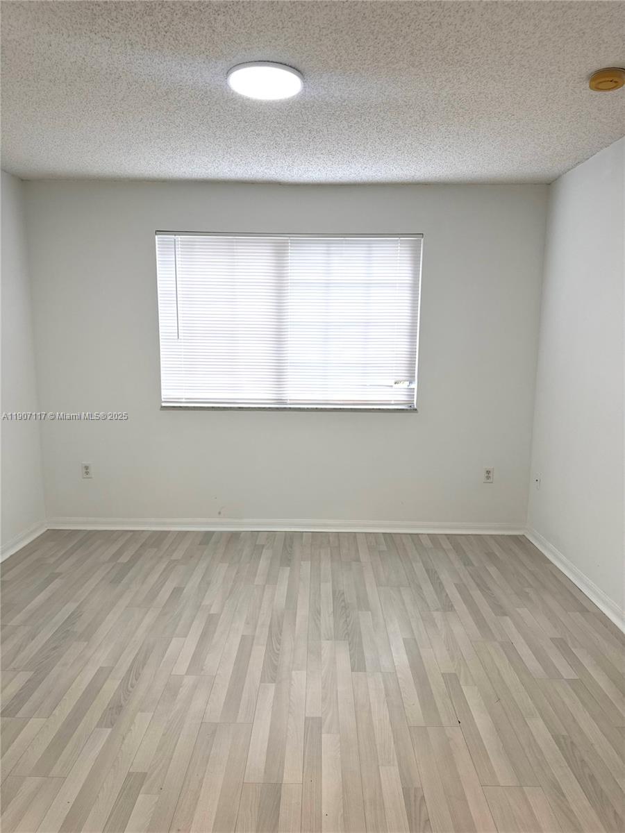 2009 Southeast 10th Avenue, Unit 315 Fort Lauderdale, FL 33316 - Photo 7 of 9 an empty room with wooden floor and windows