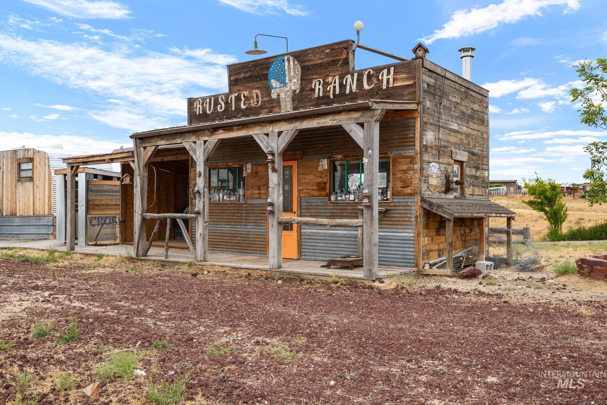 870 Desert Wind Road Boise, ID 83716 - Photo 45 of 50 Rustic facade featuring a covered porch, wood-plank siding, and an orange entry door