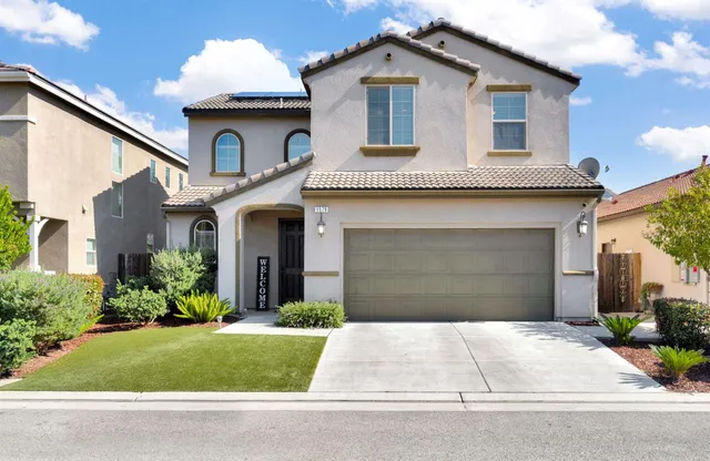 a front view of a house with a yard and garage