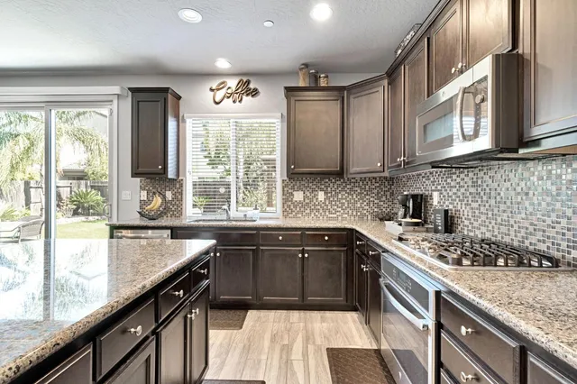 a kitchen with a sink stove top oven and refrigerator