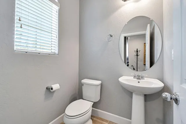 a bathroom with a toilet sink and mirror