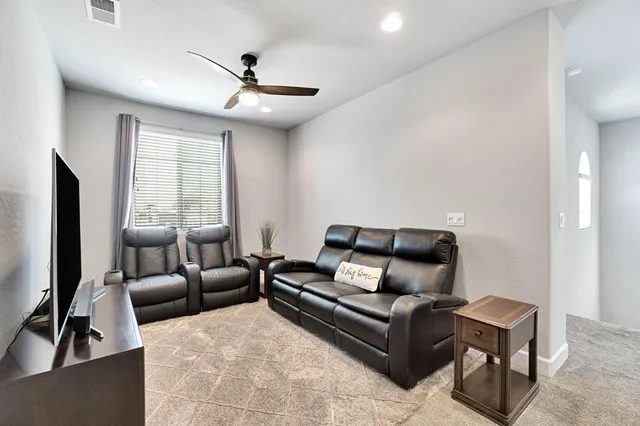 a living room with furniture ceiling fan and a window