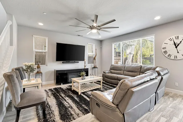 a living room with furniture a fireplace and a flat screen tv