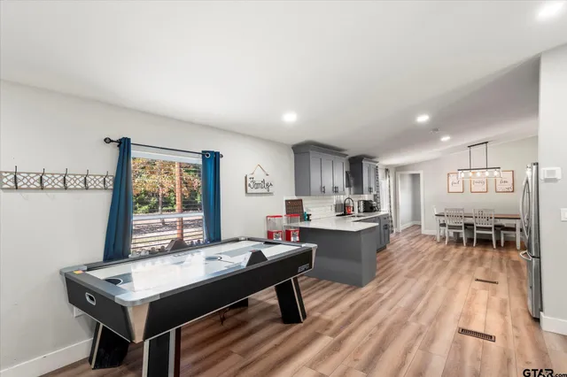 a kitchen with a dining table chairs stove refrigerator and cabinets