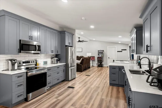a kitchen with stainless steel appliances granite countertop a refrigerator stove and sink