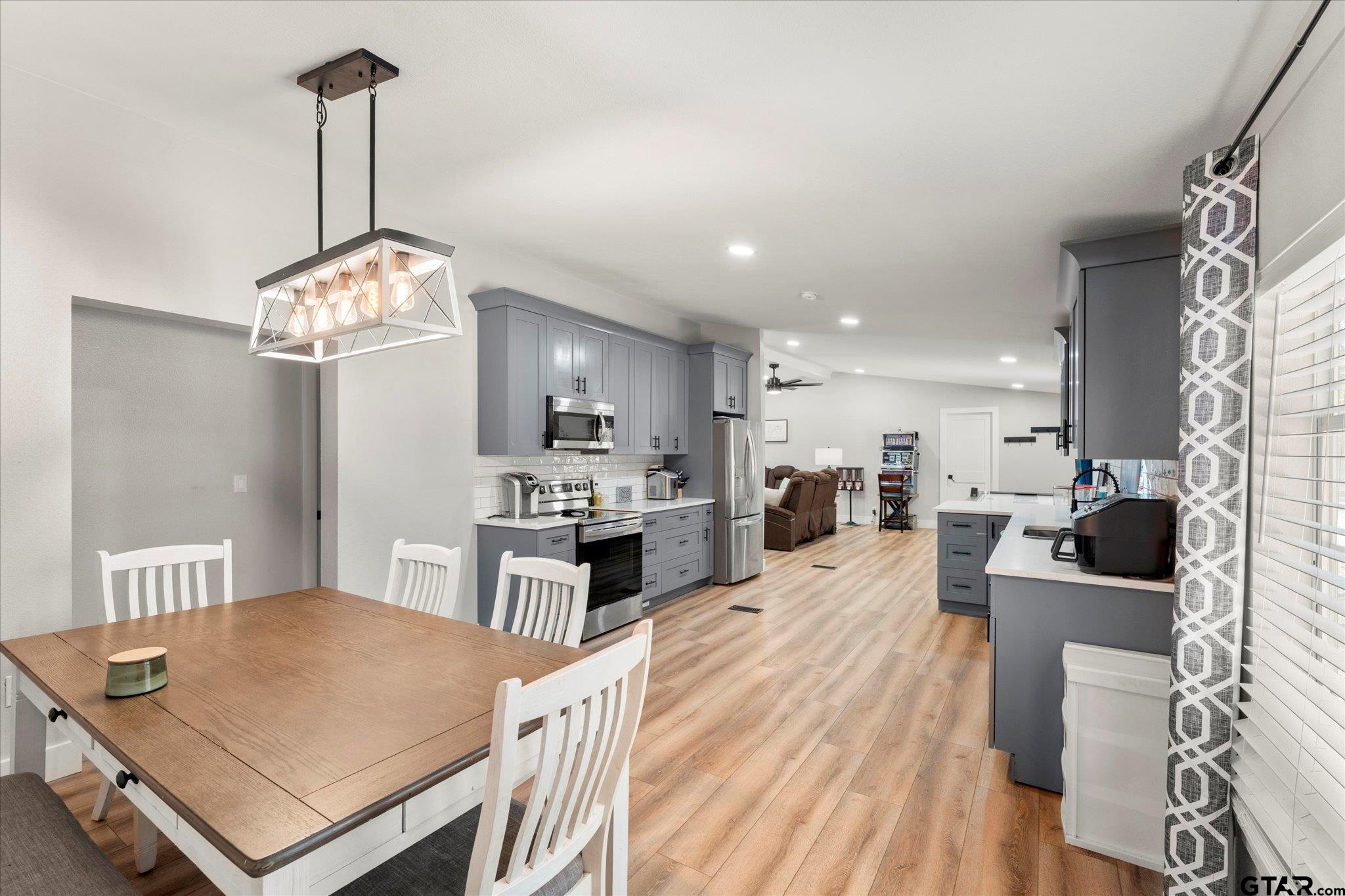 170 Private Road Leesburg, TX 75451 - Photo 30 of 46 a open kitchen with stainless steel appliances granite countertop a stove refrigerator a dining table and chairs with wooden floor