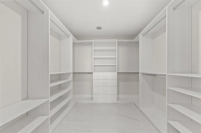 a view of walk in closet with empty racks