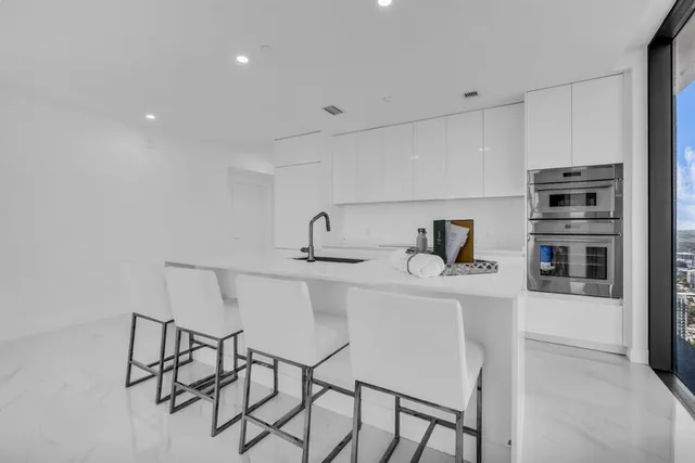 a kitchen with stainless steel appliances a sink and a refrigerator