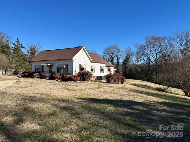 a view of a white house with a yard
