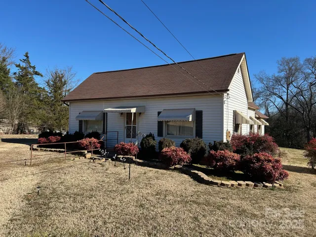 a view of a house with yard and sitting area