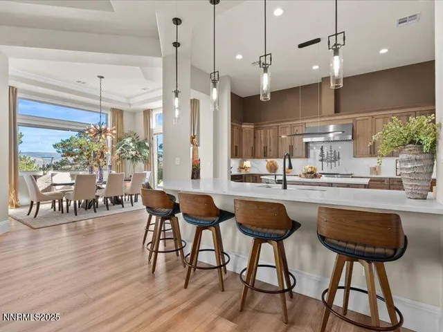 a kitchen with stainless steel appliances granite countertop a kitchen island a stove a cabinets and a chairs