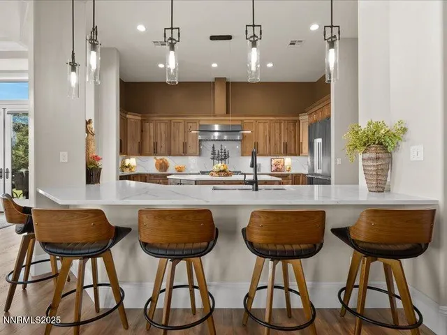 a kitchen with stainless steel appliances granite countertop a table chairs and a chandelier
