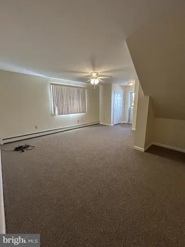 a view of a big room with windows and chandelier fan
