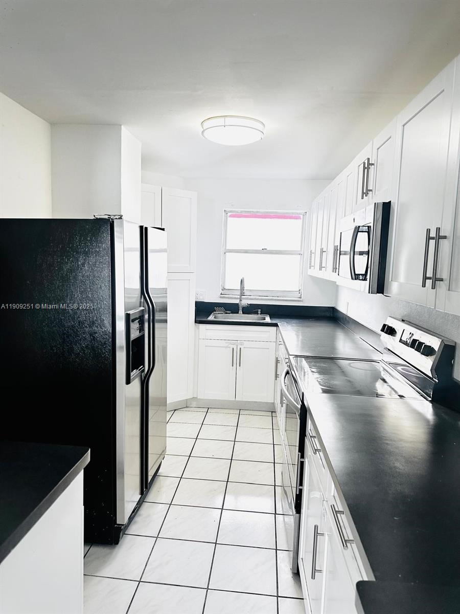 1750 West 46th Street, Unit 535 Hialeah, FL 33012 - Photo 16 of 26 a kitchen with stainless steel appliances granite countertop a refrigerator and a sink