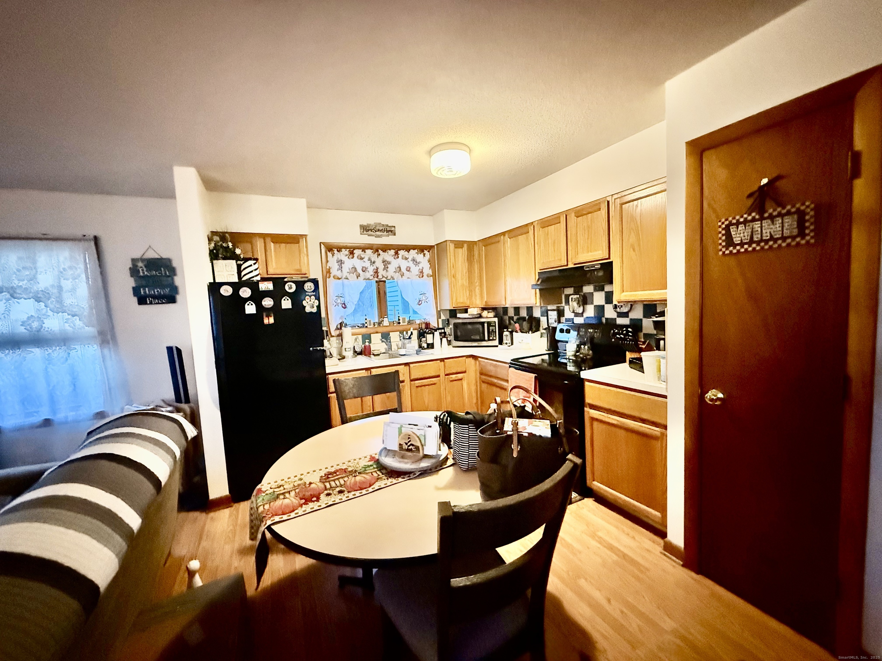 226 West High Street East Hampton, CT 06424 - Photo 16 of 21 a kitchen with stainless steel appliances granite countertop a dining table chairs and a refrigerator