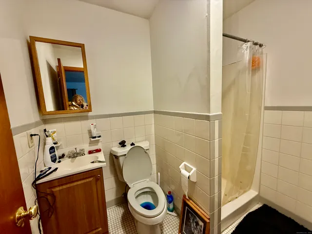 a bathroom with a sink and a washing machine with a mirror
