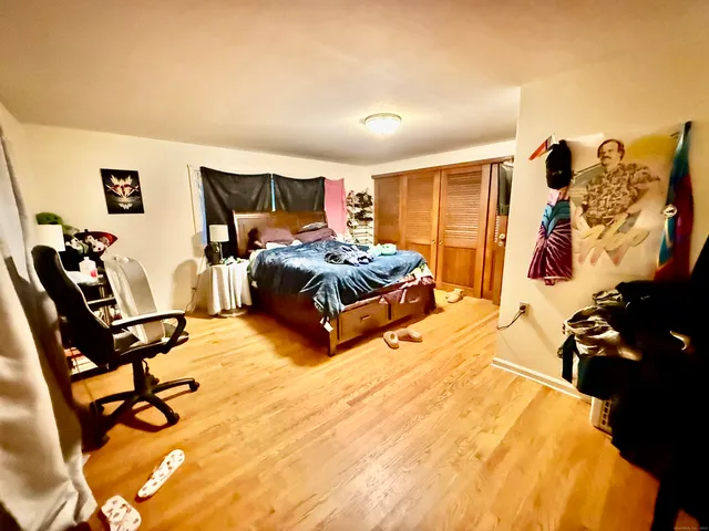 a bedroom with a bed and wooden floor