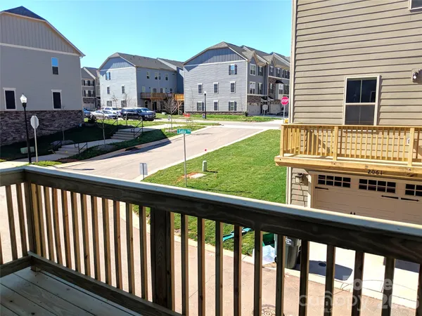 a view of a house with a small yard and wooden fence