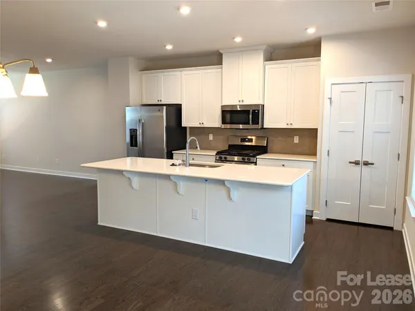 a kitchen with stainless steel appliances a refrigerator sink and microwave