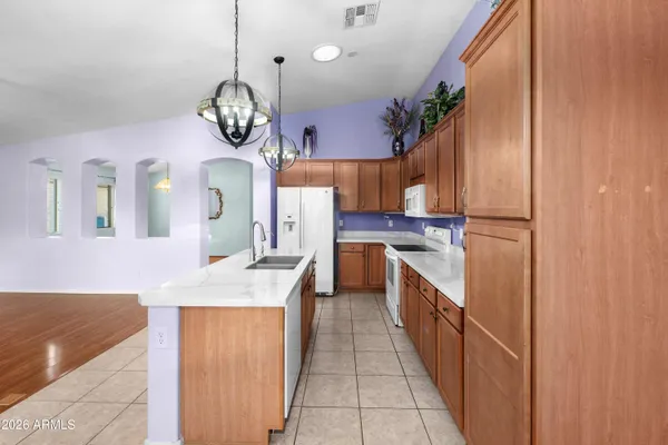 a kitchen with stainless steel appliances granite countertop a sink dishwasher a stove a dining table and chairs with wooden floor