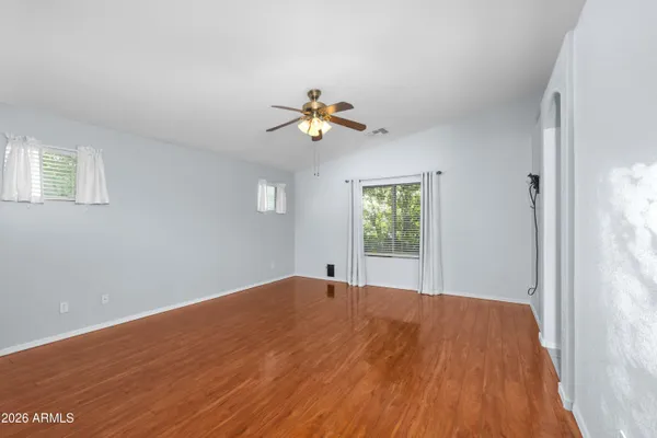 a view of empty room with wooden floor