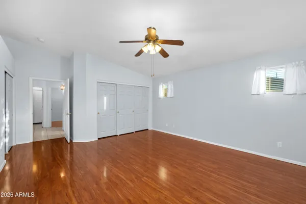 a view of a livingroom with a chandelier fan and wooden floor