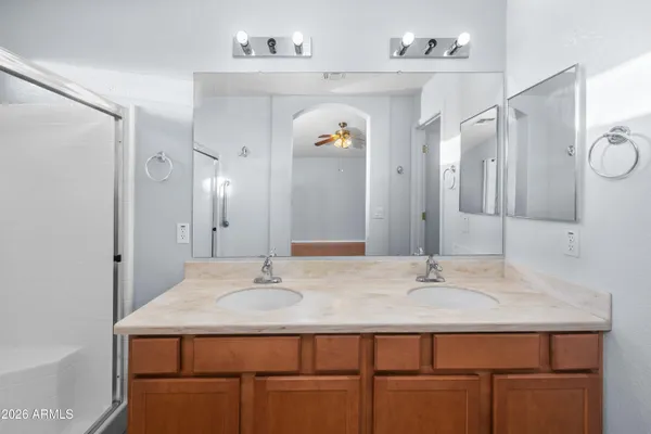 a bathroom with a granite countertop sink mirror shower and