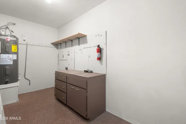 a view of a storage & utility room with refrigerator and window
