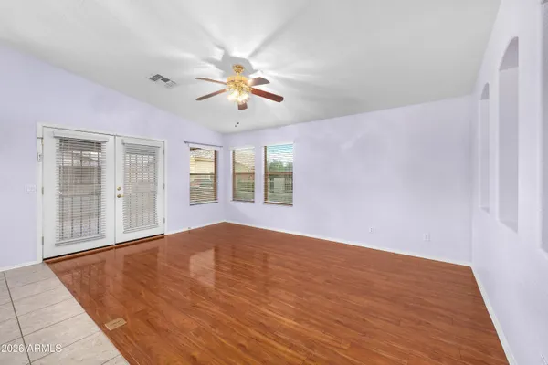 a view of an empty room with a window and wooden floor