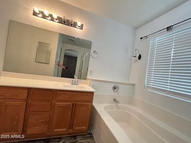a bathroom with a tub a sink and mirror